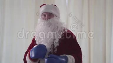 戴着蓝色拳击手套的长胡子滑稽圣诞老人的肖像想打特写。 老人威胁地看着